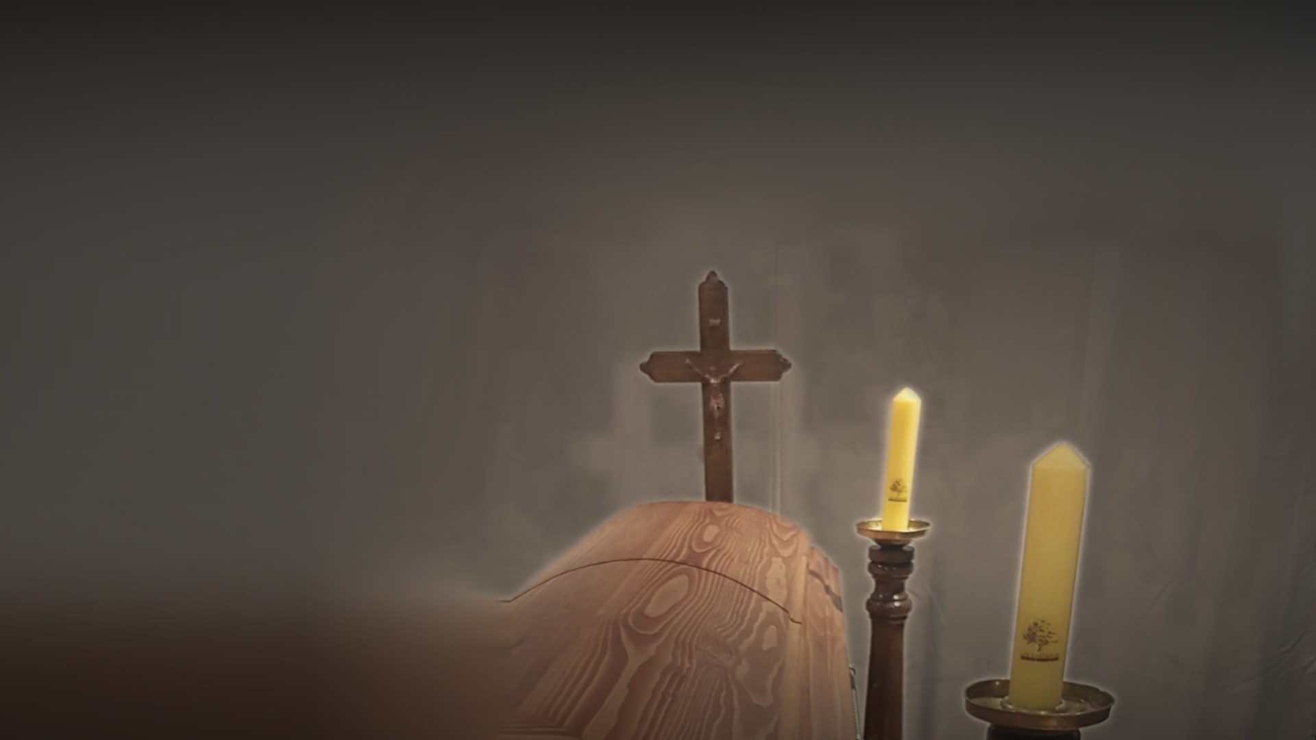 Cruz de madera, féretro y cirios en una sala de velatorio de Los Castaños